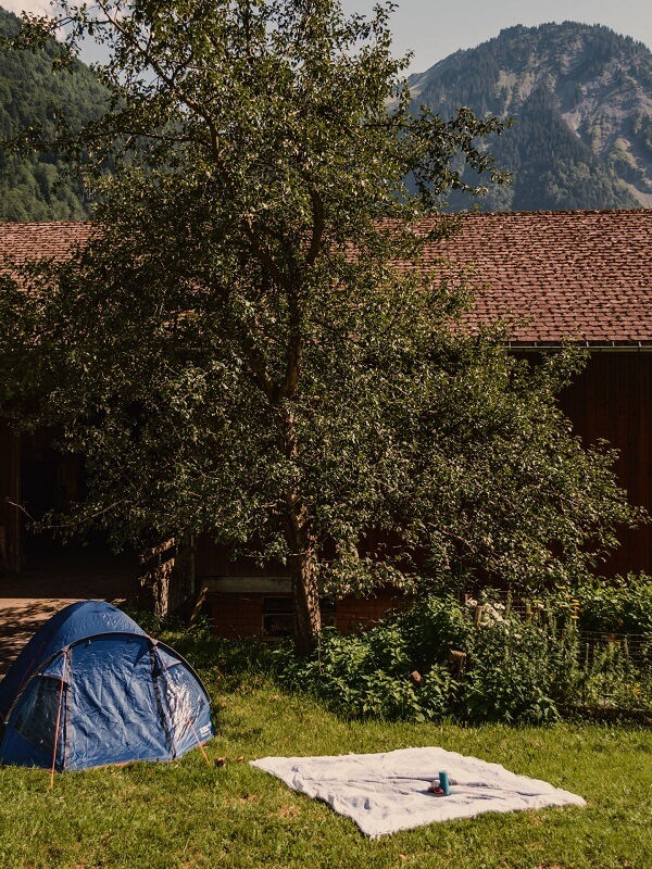 Zelten in der Schweiz mit Biohof tschingelgut mit kleinem Zelt und Picknickdecke