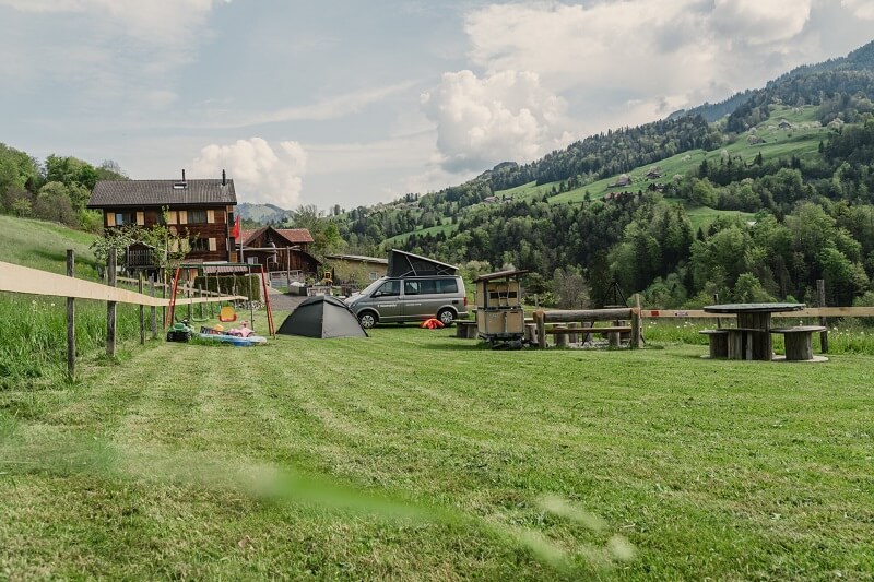 Campen in der Schweiz: Zeltplatz in den Bergen mit Spielplatz für Kinder und Sitzgelegenheiten